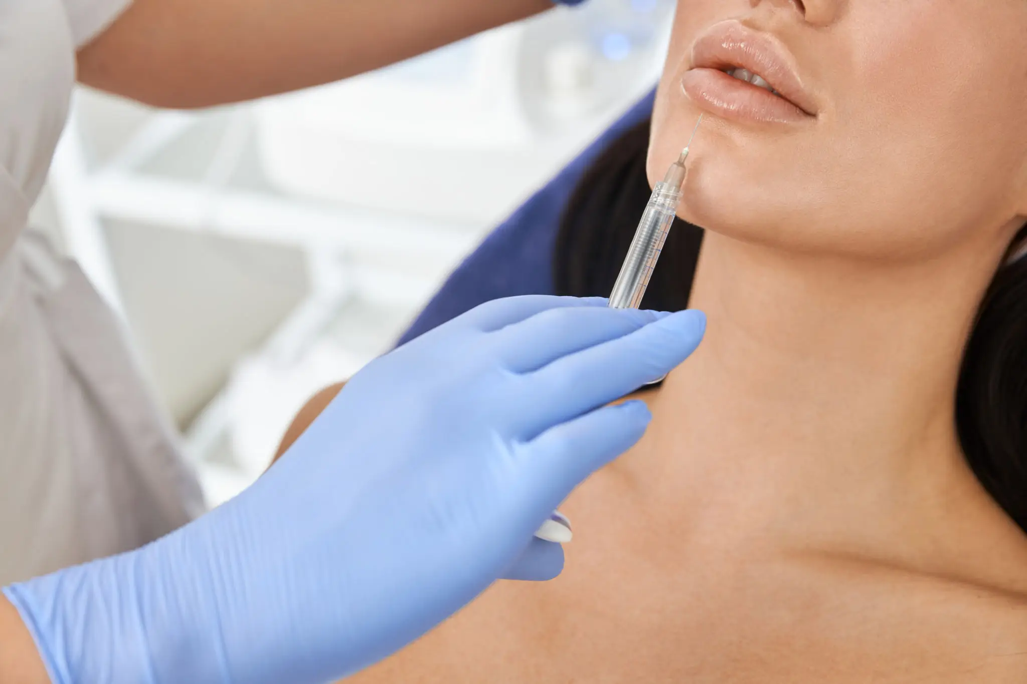 A person receiving a facial injection from a gloved professional.