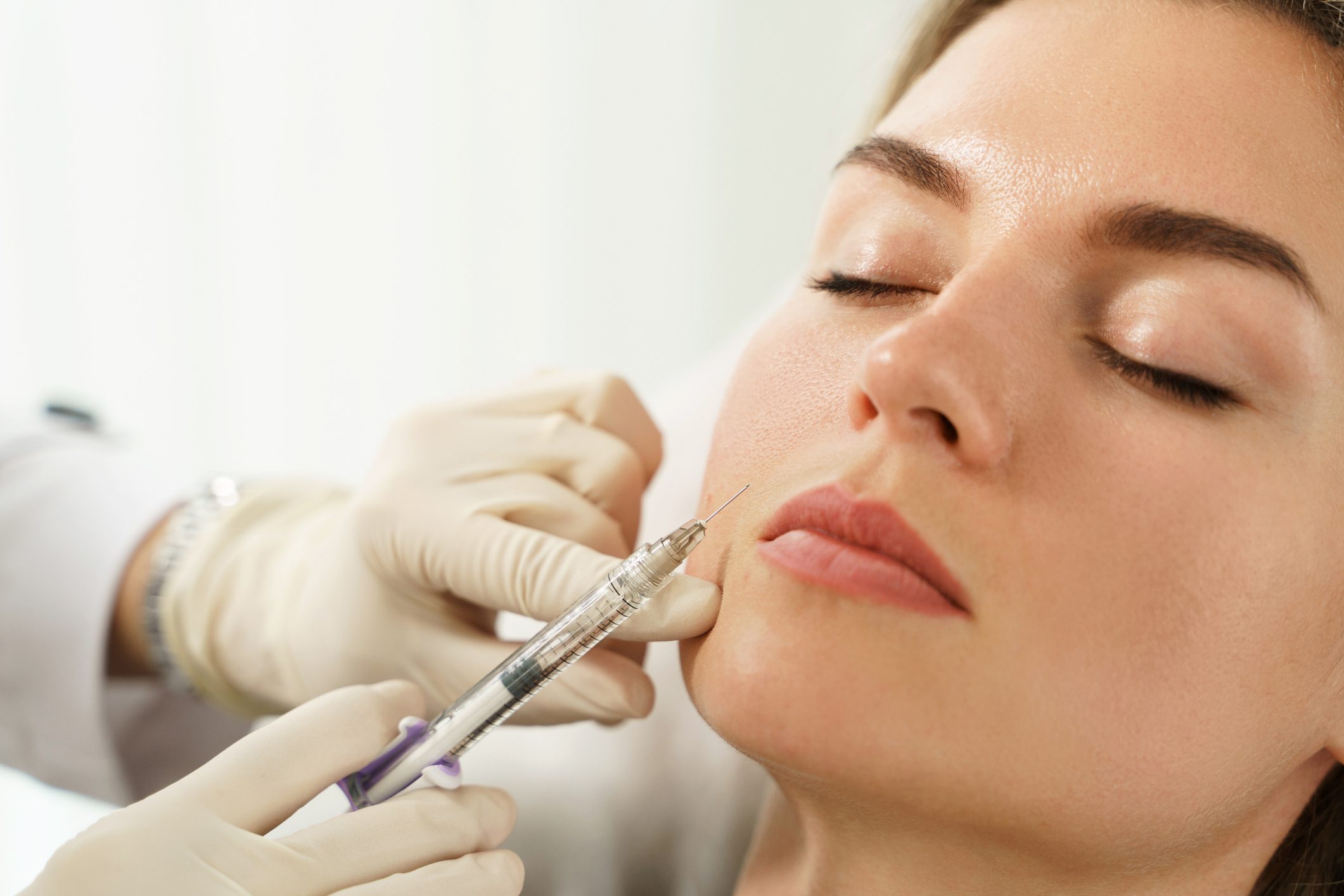 Woman receiving a cosmetic lip injection.